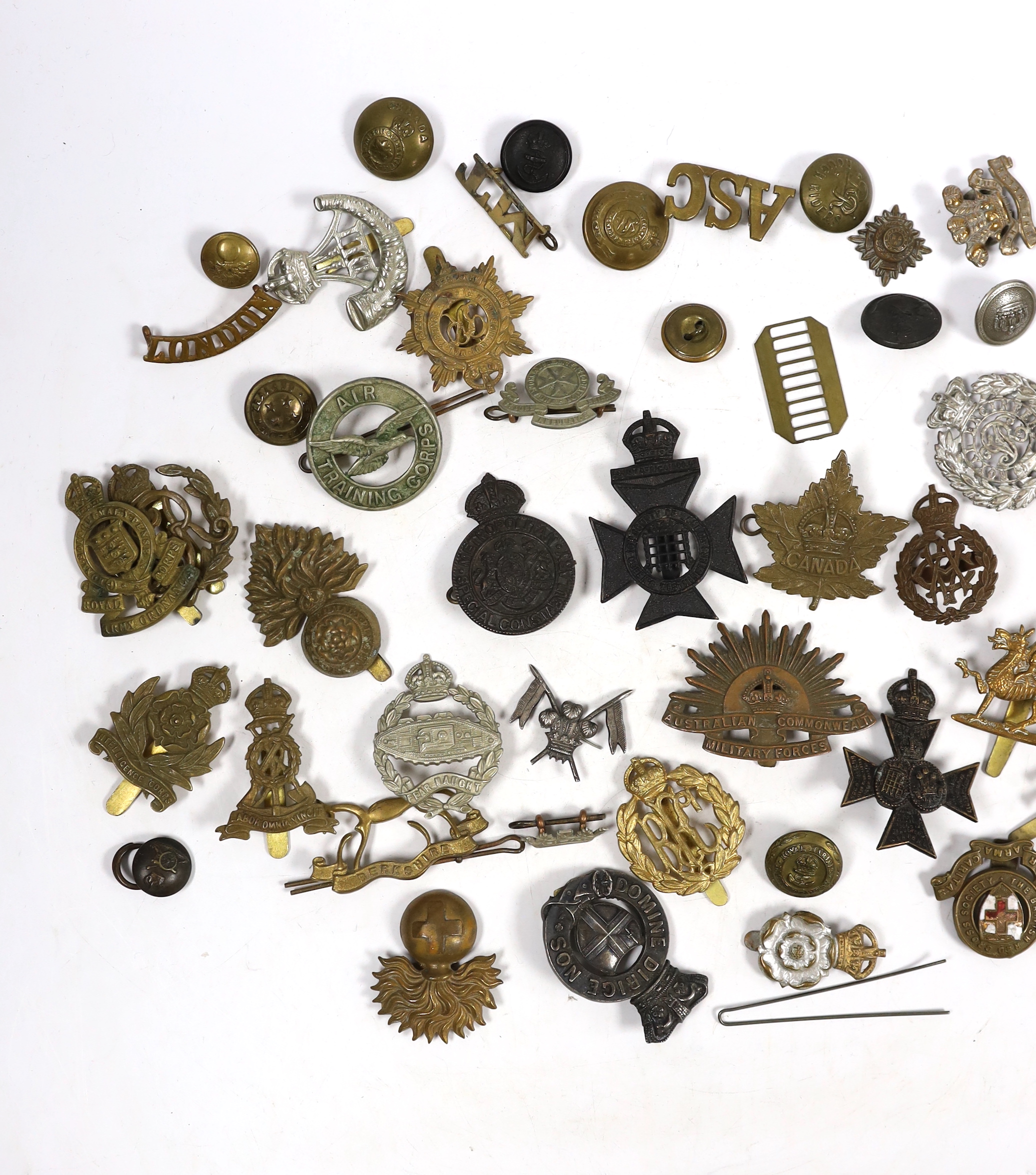 Twenty-five military cap badges including Air Training Corps, Australian Commonwealth Military Forces, Royal Army Ordinance Corps, Royal Engineers, Intelligence Corps, Royal Army Service Corps, RFC, etc. Together with a